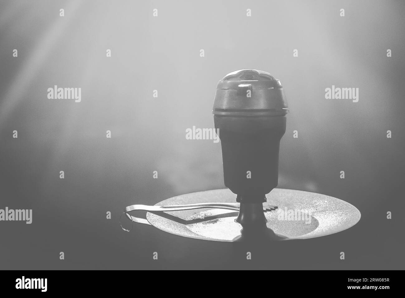 Oggetto fumante nel recipiente con testa a narghilè in primo piano grigio scuro chiaro. Foto Stock