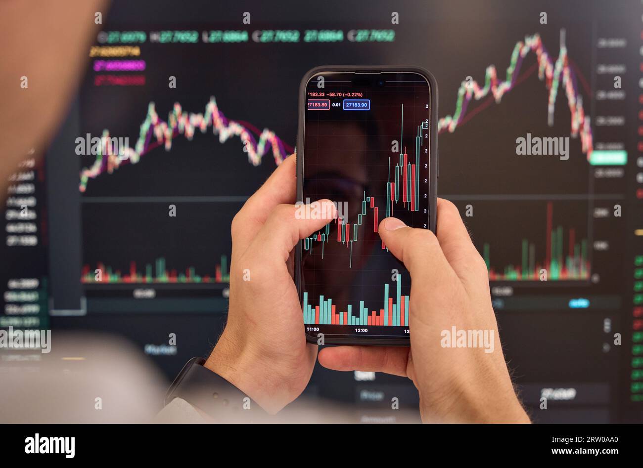 Investitore trader che analizza il mercato mobile degli investimenti delle azioni crittografiche. A spalla Foto Stock