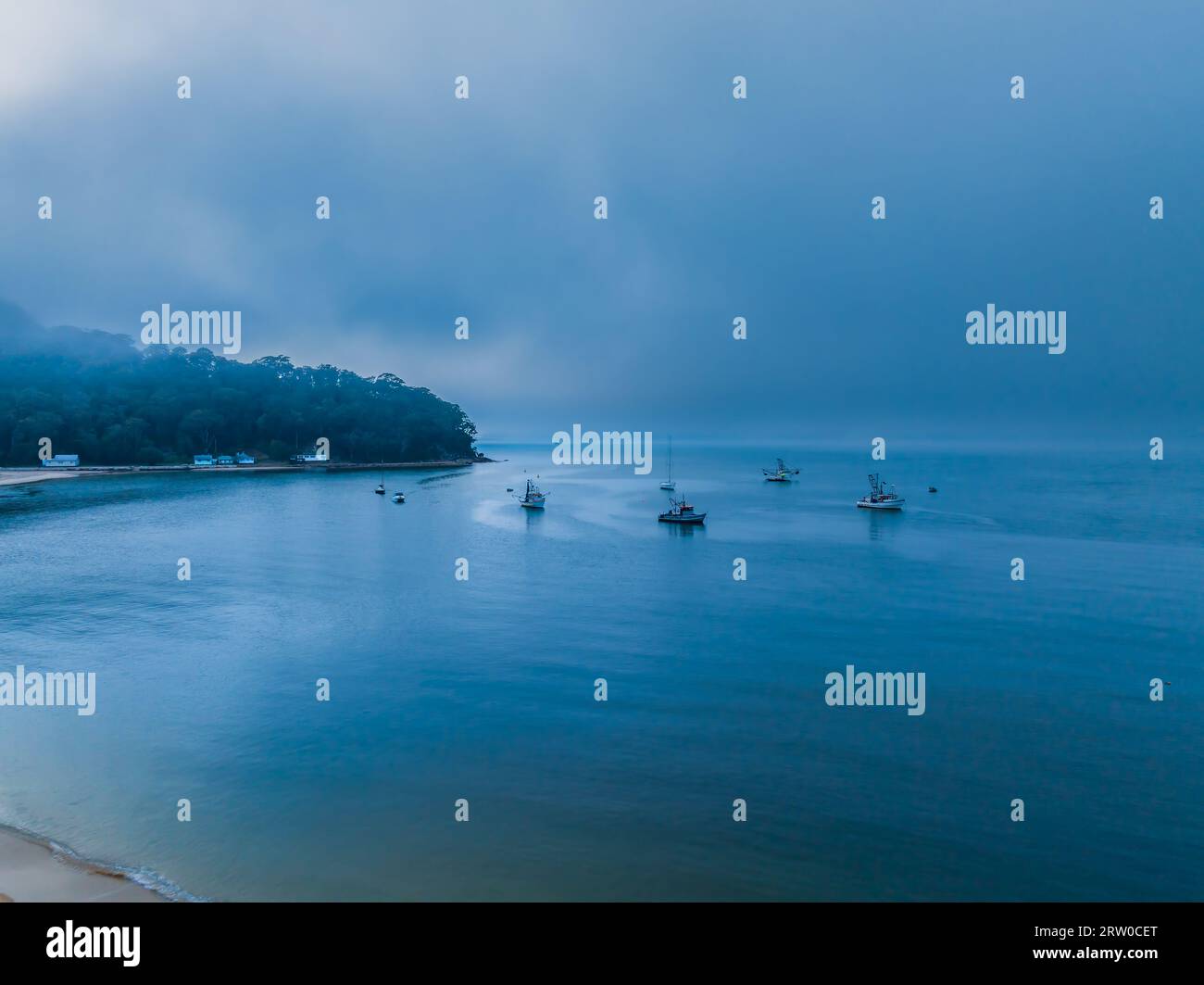 Alba e nebbia su Brisk Bay con barche al villaggio di mare di Patonga Beach sulla costa centrale del New South Wales, Australia. Foto Stock