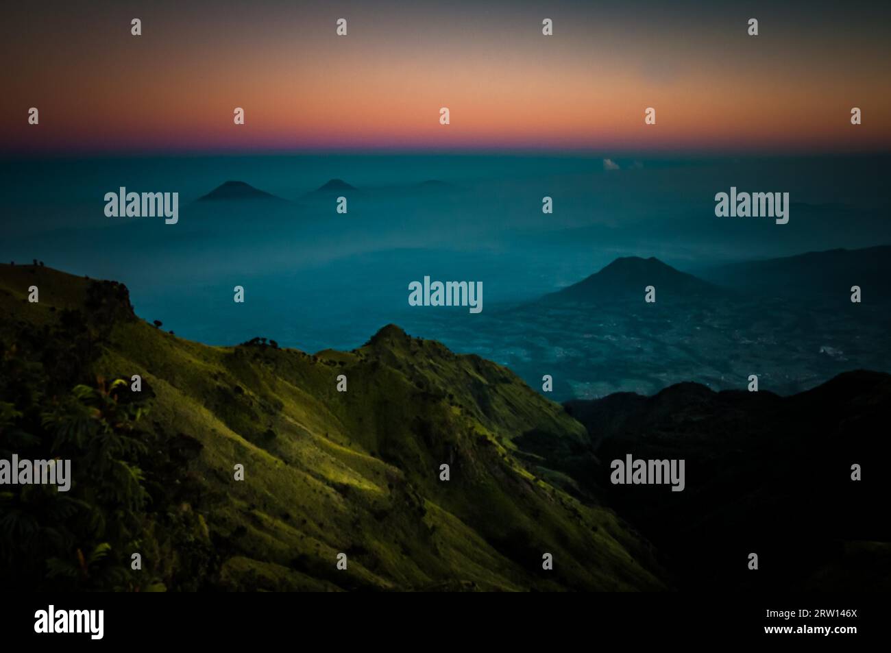 Foto panoramica dello stratovulcano dormiente, del Monte Merbabu e delle montagne circostanti coperte di nebbia durante l'alba vicino a Yogya nel centro di Giava Foto Stock