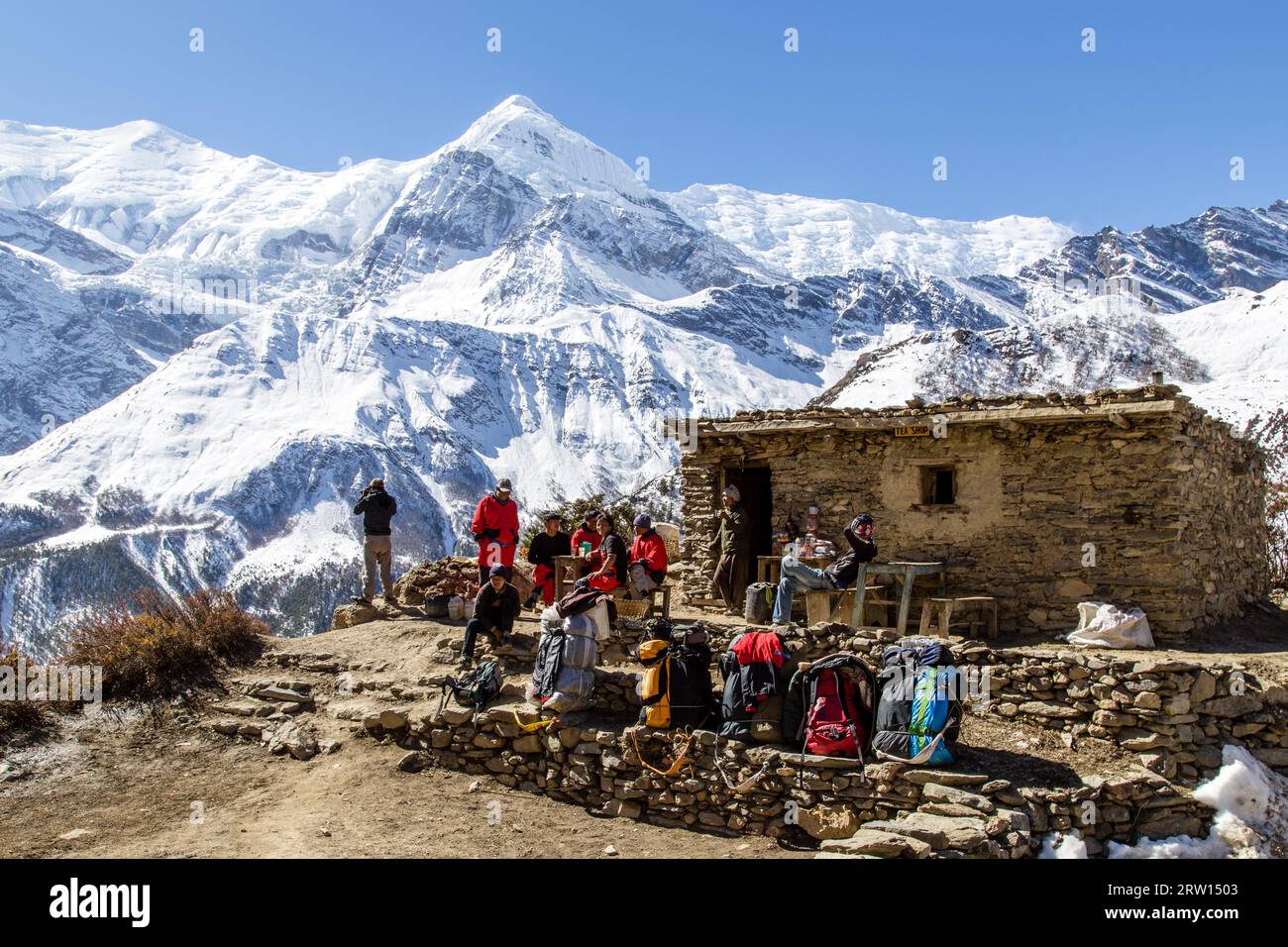 Annapurna area, Nepal, 30 ottobre 2104: Gruppo di escursionisti che fanno una sosta in una capanna nelle montagne innevate dell'Annapurna Conservation area Foto Stock