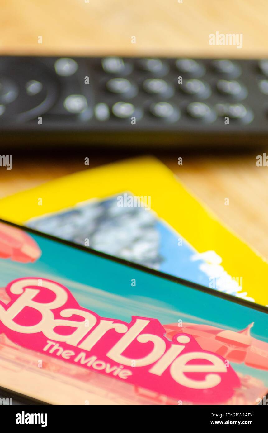 Madrid, Spagna 09 15 2023: Messa a fuoco selettiva, Barbie il logo del film visualizzato su uno smartphone e un telecomando tv Foto Stock