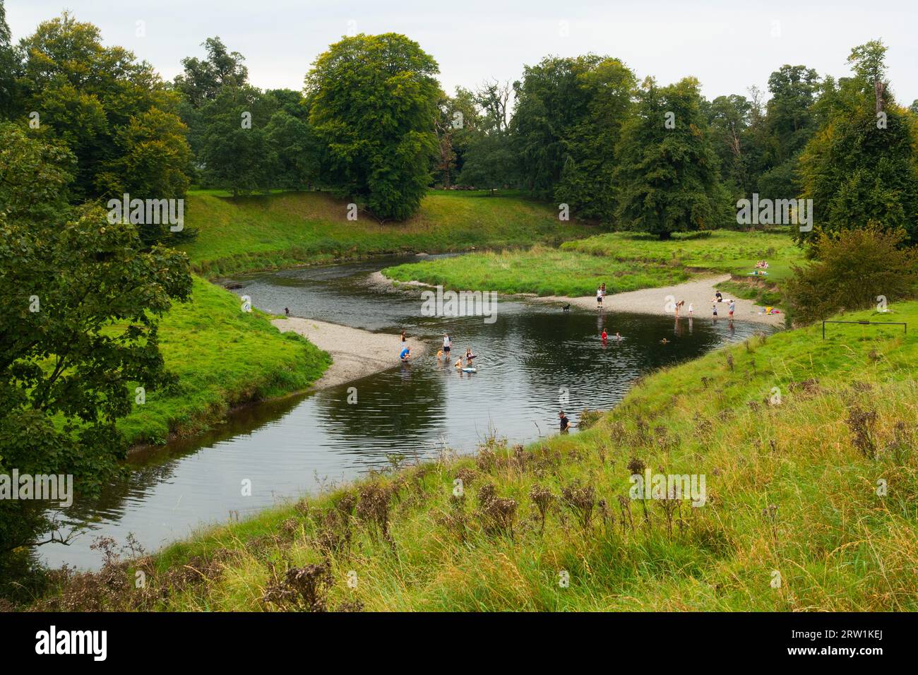 Il fiume Kent scorre attraverso i terreni di Levens Hall, vicino a Kendal, Cumbria, un luogo balneare popolare per le famiglie Foto Stock