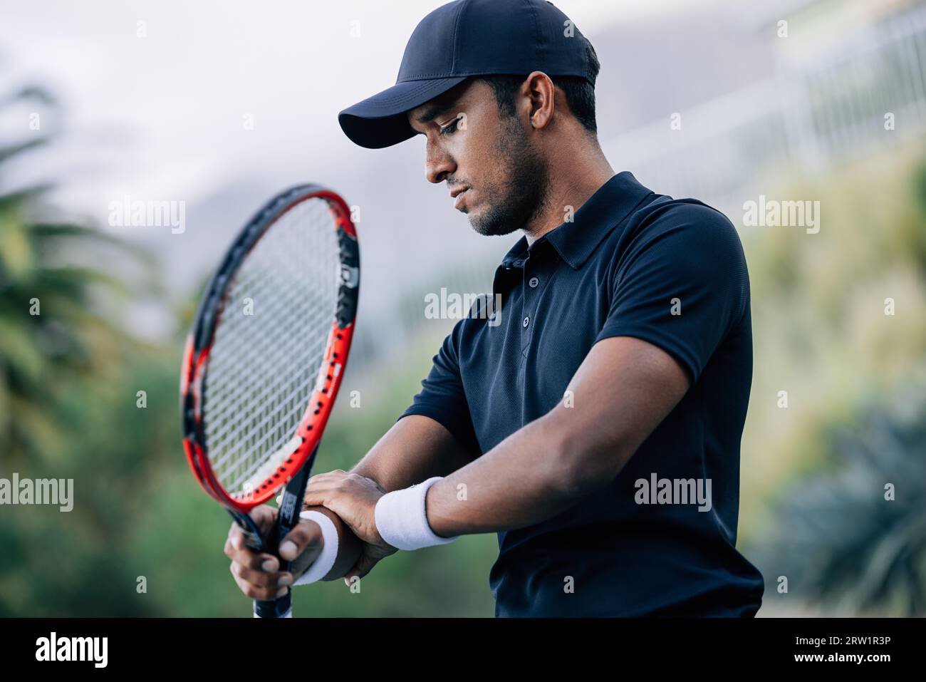 Tennista professionista che tocca il braccio durante l'allenamento Foto Stock
