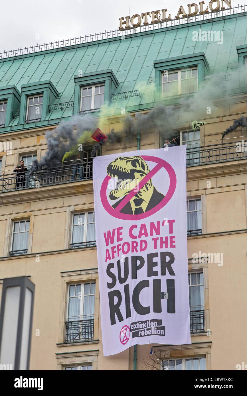 13.04.2023, Germania, Berlino, Berlino - Extinction Rebellion, attivisti del clima dirottano Hotel Adlon. I manifestanti accendono candele fumose e svelano uno striscione W. Foto Stock