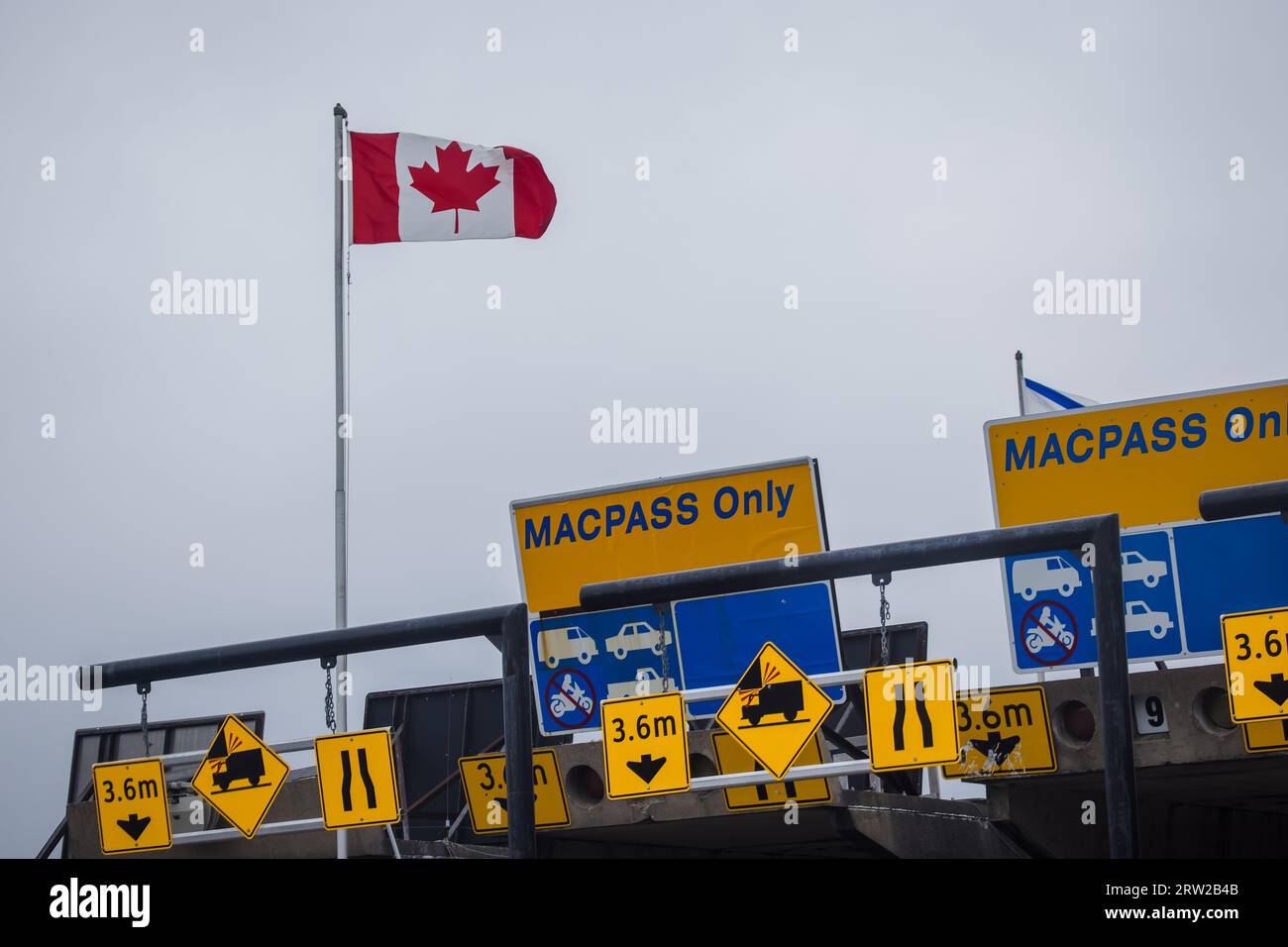 Bandiera del Canada e banner MACPASS al MacKay Bridge Toll Plaza. MAC PASS è un sistema elettronico di pedaggio per Halifax Harbour Bridges HHB. HALIFAX, NS, CAN Foto Stock