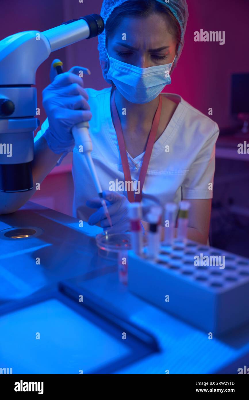 Giovane dipendente di un moderno laboratorio criogenico lavora con biomateriali Foto Stock