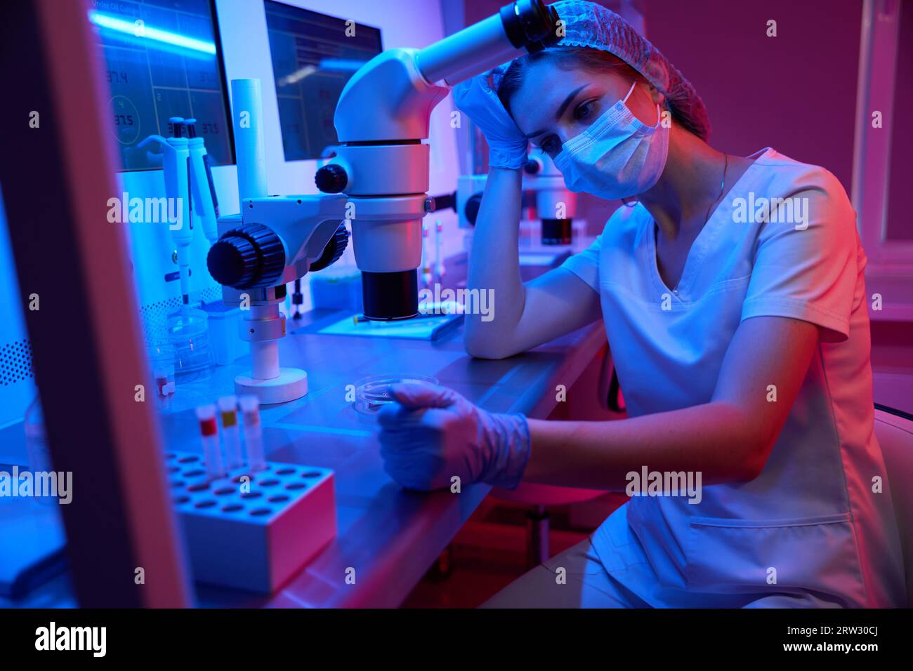 Giovane donna stanca sul posto di lavoro in un laboratorio moderno Foto Stock