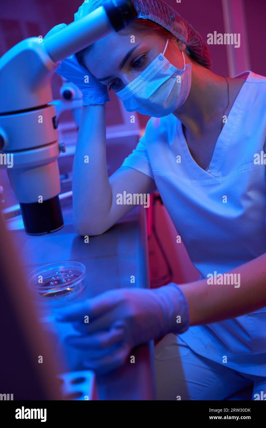 Assistente di laboratorio stanco sul posto di lavoro in un laboratorio moderno Foto Stock