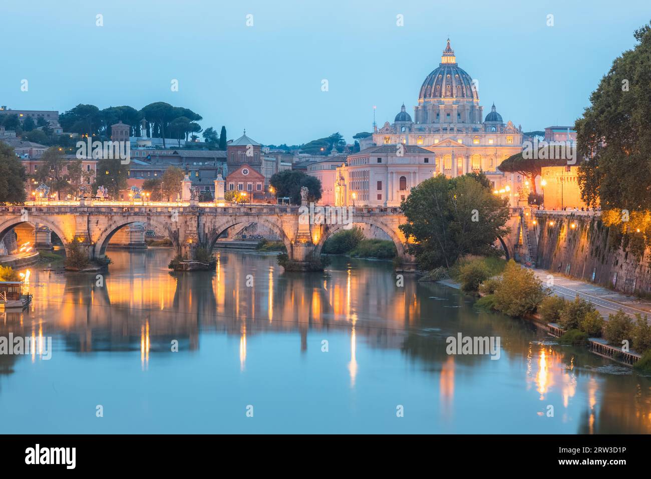 Panorama al crepuscolo della basilica di San Pietro a città del Vaticano e Ponte Vittorio Emanuele II illuminato lungo il fiume Tevere in una sera d'estate Foto Stock