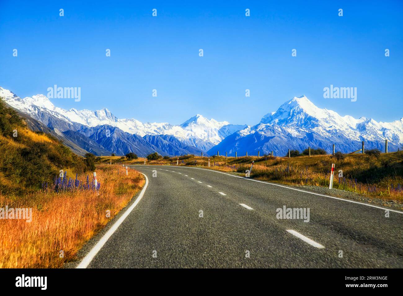 Asfalto dell'autostrada 80 su South Island in nuova Zelanda presso il lago Pukaki, in direzione delle maestose montagne del Monte Cook. Foto Stock