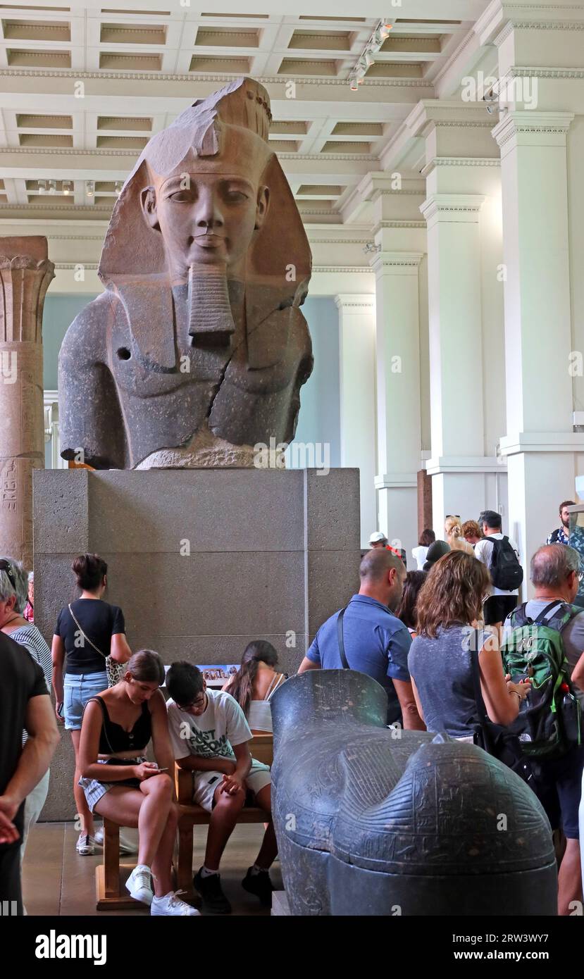 Turisti nelle camere dell'Antico Egitto, colossale testa di granito di Re Amenofi III, British Museum, Great Russell St, Bloomsbury, Londra, Inghilterra, REGNO UNITO Foto Stock