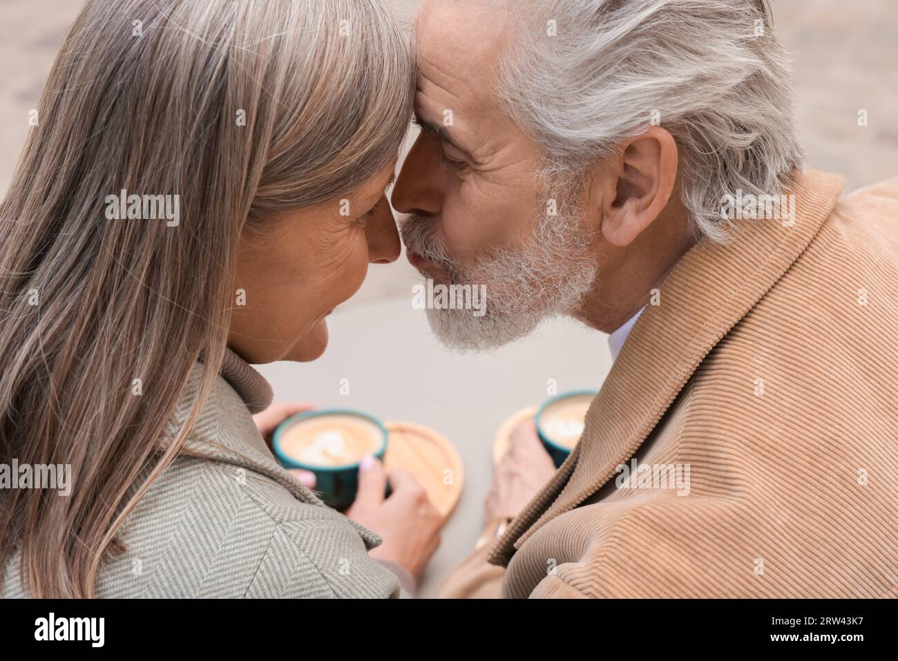 Ritratto di una coppia anziana affettuosa che si bacia all'aperto, primo piano Foto Stock