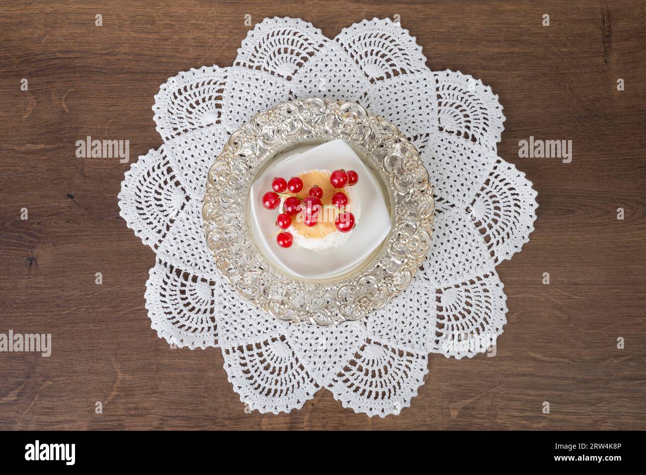 Biscotti al cocco con ribes serviti in una piccola ciotola su una coperta a uncinetto. Vista dall'alto Foto Stock