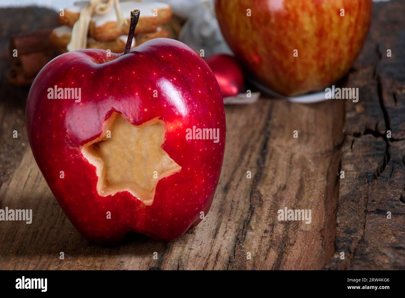 Una mela rossa con una stella tagliata su legno scuro Foto Stock