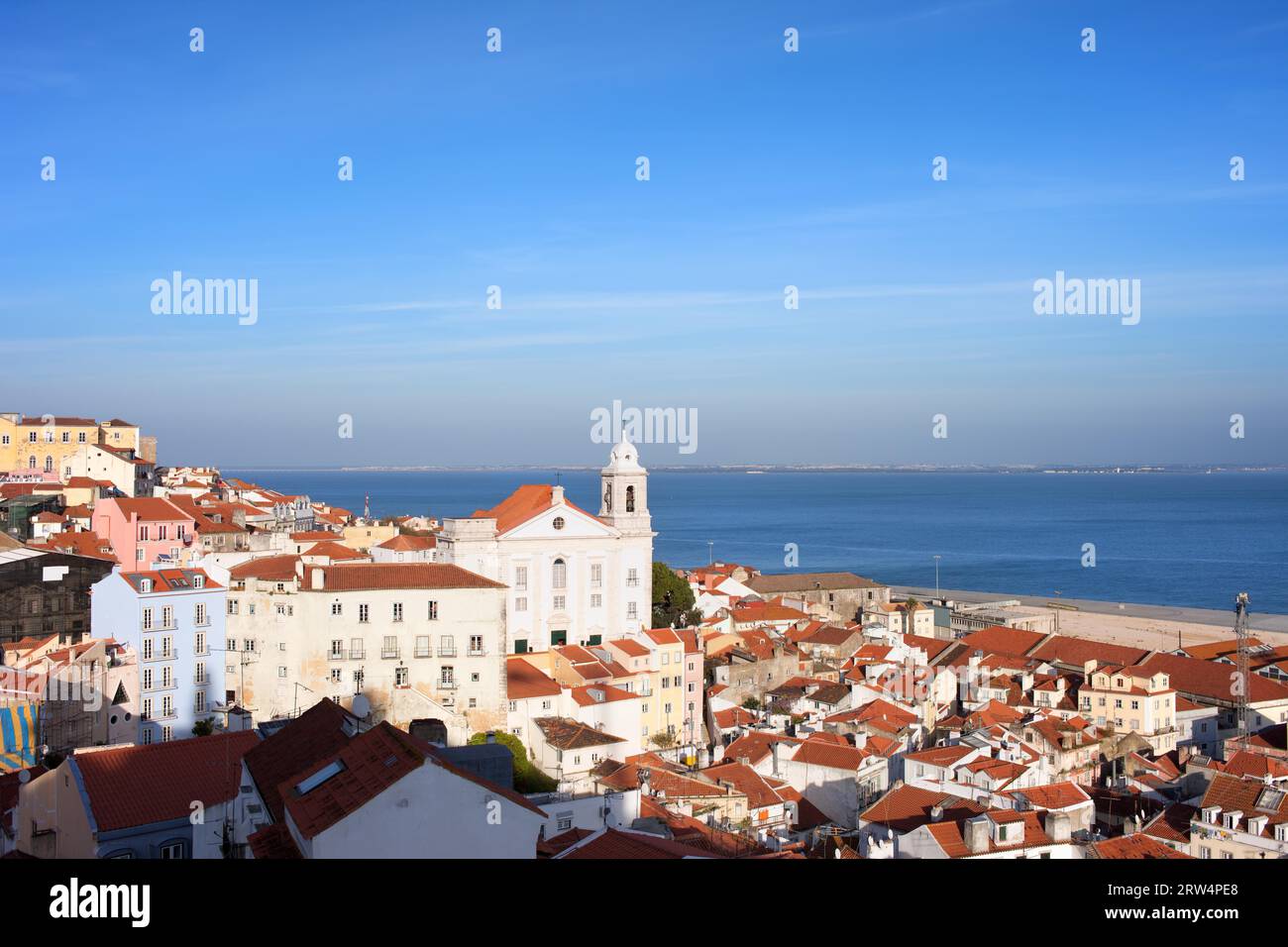 Ammira il quartiere di Alfama nella città di Lisbona, Portogallo, la chiesa di Santo Estevao nel mezzo, il fiume Tago sullo sfondo Foto Stock