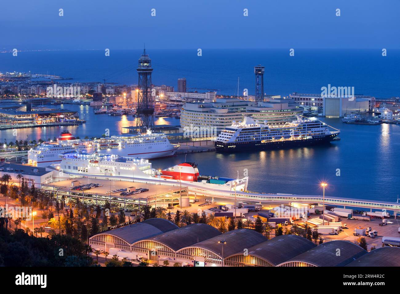 Città di Barcellona di notte in Catalogna, Spagna. Navi attraccate al terminal del porto crocieristico di Moll Adossat, acqua del Mar Mediterraneo Foto Stock