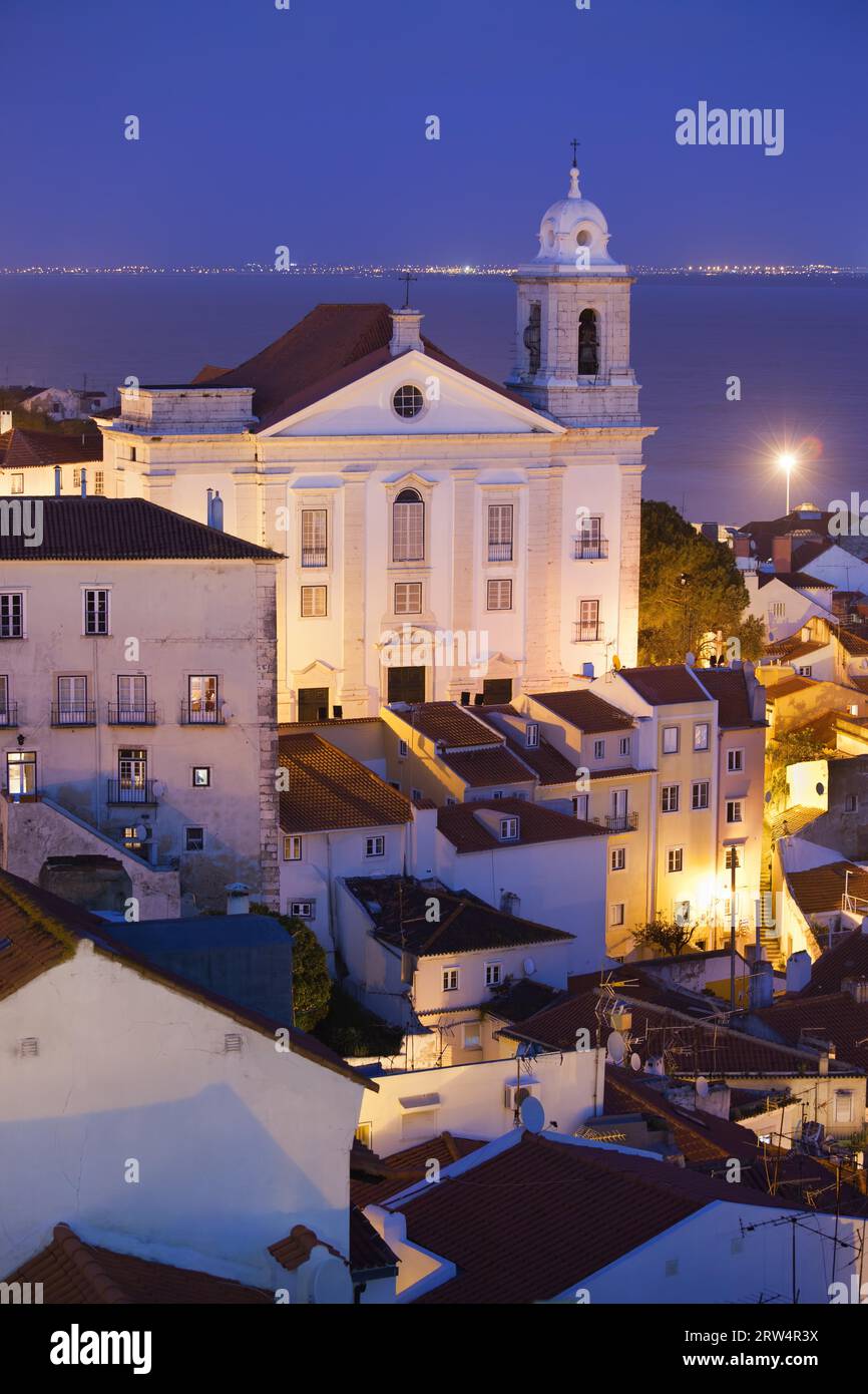 Chiesa di Santo Estevao di notte nella città vecchia di Lisbona in Portogallo, fiume Tago sullo sfondo Foto Stock
