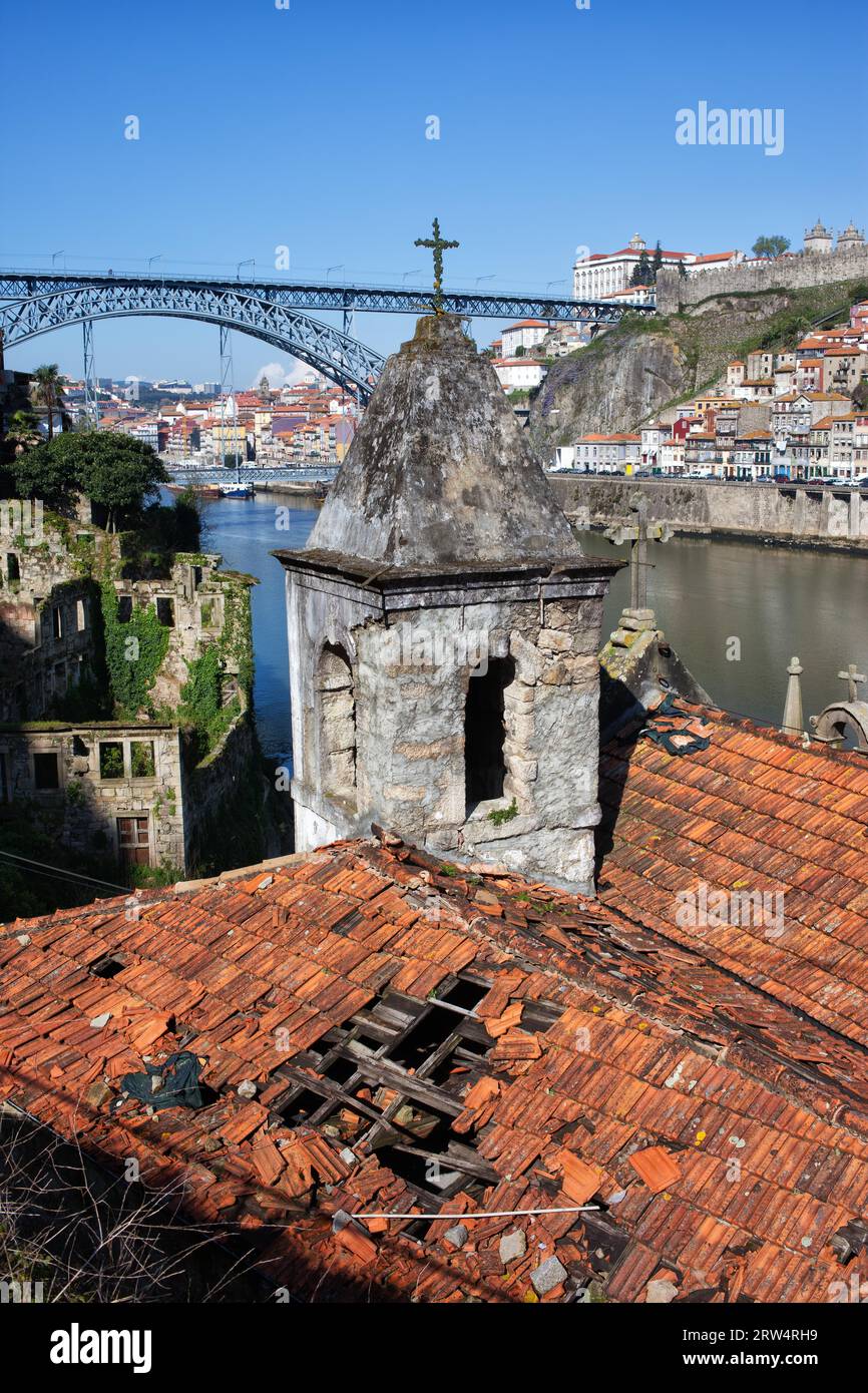 Un'antica chiesa abbandonata a Vila Nova de Gaia, Portogallo, lo skyline della città vecchia di Porto con Ponte Luiz i Ponte i sullo sfondo Foto Stock
