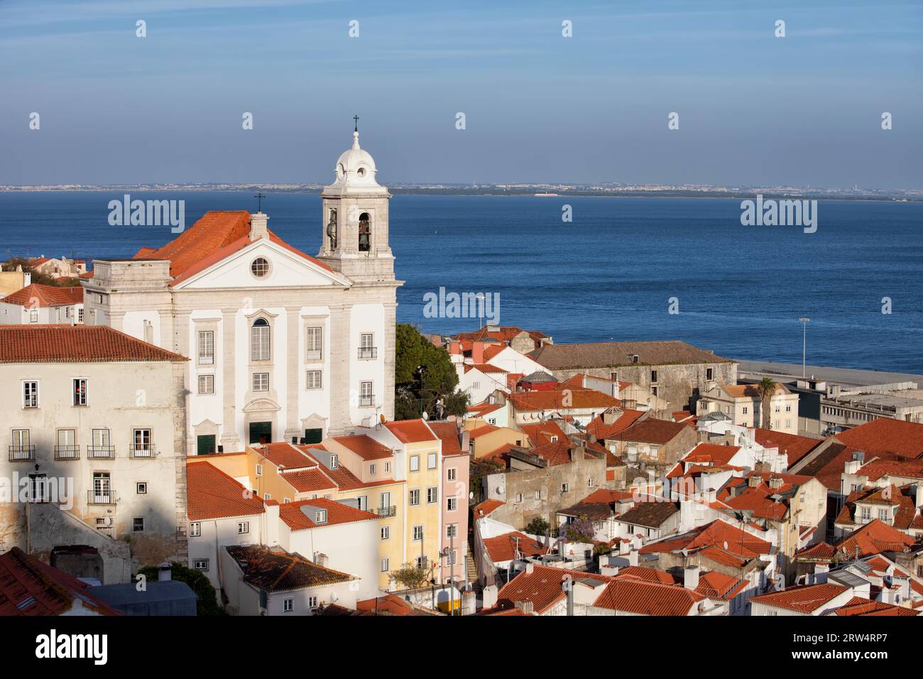Città di Lisbona in Portogallo, vista sul quartiere di Alfama con la chiesa di Santo Estevao e il fiume Tago sullo sfondo Foto Stock