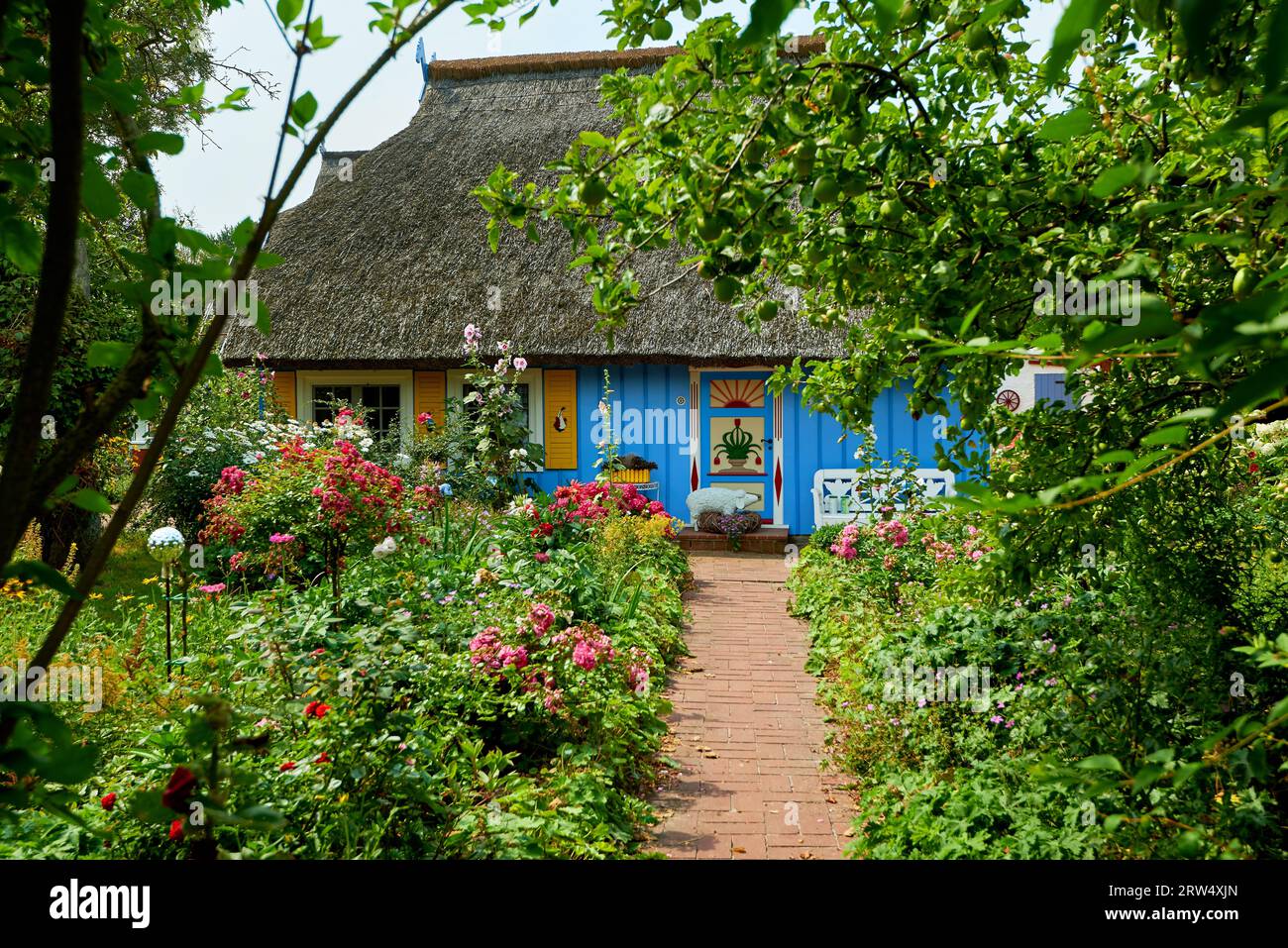 Giardino idilliaco con casa di pescatori blu Foto Stock