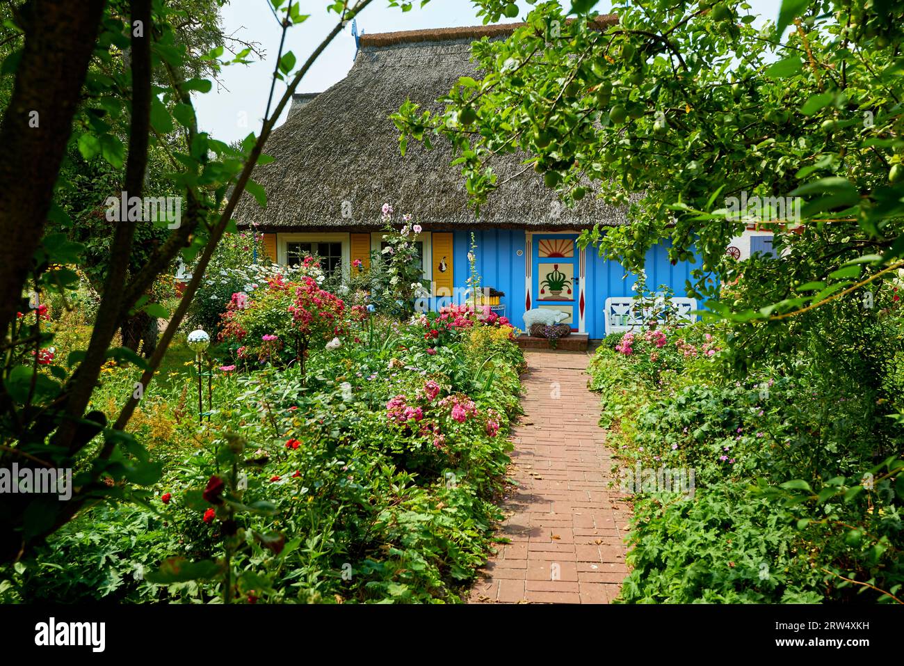 Giardino idilliaco con una casa di pescatori con tetti di paglia blu Foto Stock