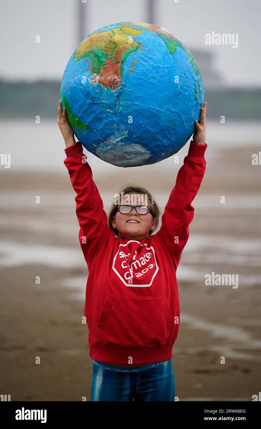 Chloe Coghlan, 12 anni, con un modello di pianeta Terra, si unisce alla società civile e ai gruppi di azione per il clima che manifestano a Sandymount Strand a Dublino, invitando il governo a intraprendere azioni urgenti per eliminare gradualmente i combustibili fossili che distruggono il clima. La loro dimostrazione fa parte di un'ondata globale di manifestazioni e marce che si stanno svolgendo in tutto il mondo, chiedendo una rapida ed equa eliminazione dei combustibili fossili. Data foto: Domenica 17 settembre 2023. Foto Stock