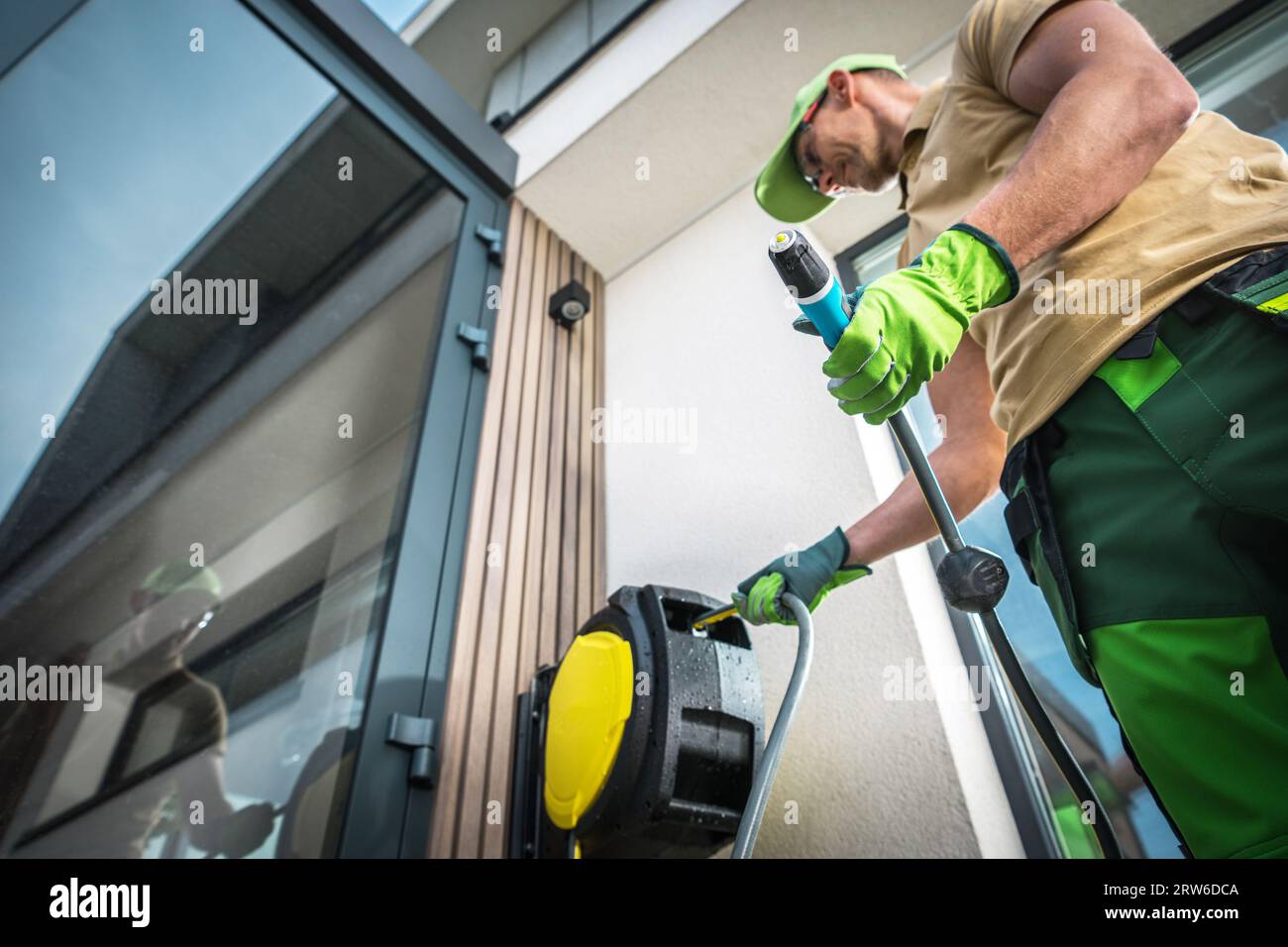Avvolgitubo da giardino caucasico e avvolgente che si prepara per l'irrigazione del giardino Foto Stock