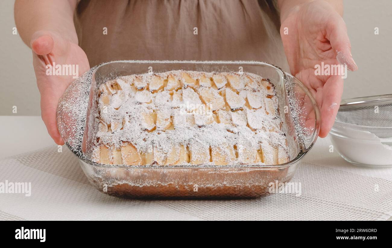 Torta di mele appena sfornata con biscotto a base ravvicinata sul tavolo da cucina, appena dal forno. Torta di condimenti con zucchero a velo. Foto Stock