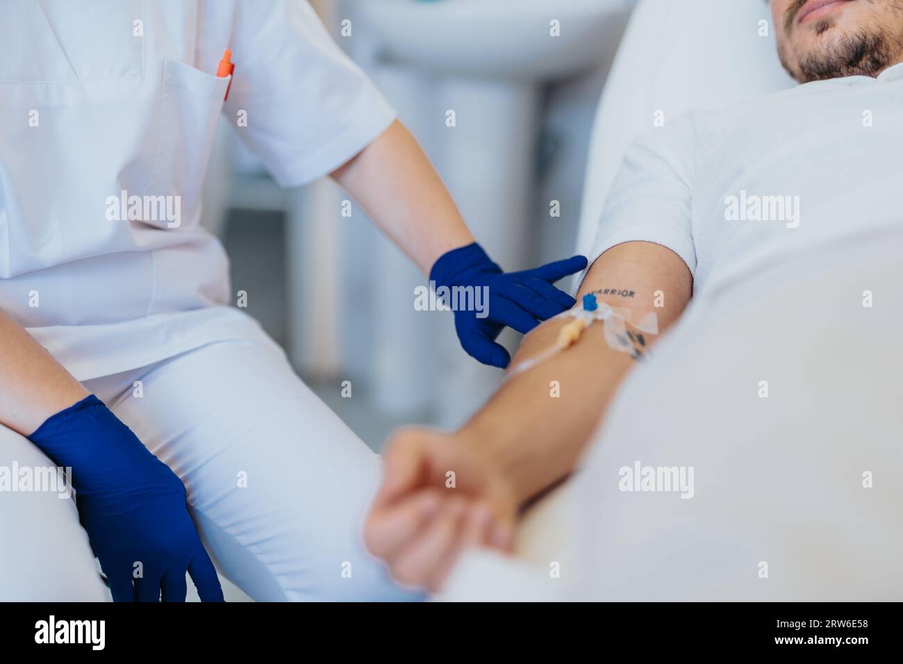 In una stanza d'ospedale, uno specialista si prende cura di un paziente con terapia di infusione. Rapporti ed esami agevolano la diagnosi. Gli operatori sanitari lavorano Foto Stock