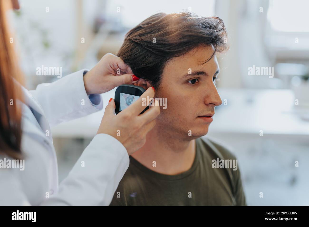 Medico che controlla l'orecchio di un paziente utilizzando il video otoscopio. Foto in primo piano. Foto Stock