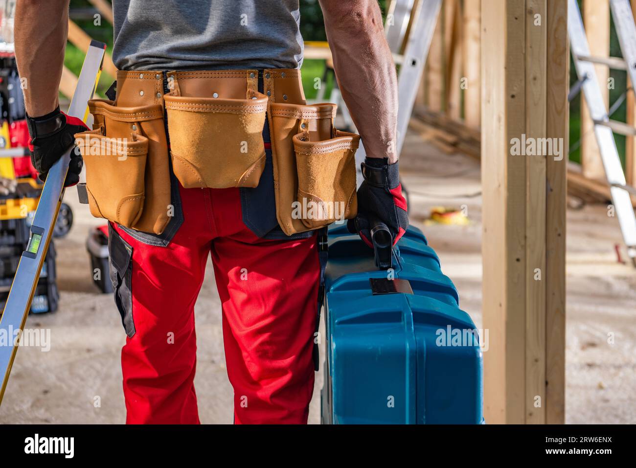 Appaltatore di costruzioni caucasico che sposta le sue attrezzature e strumenti sul sito Foto Stock