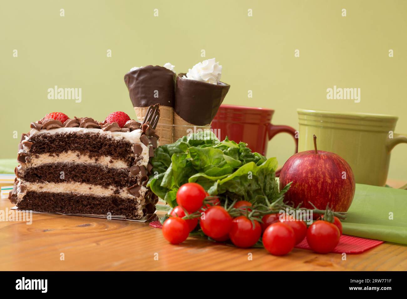 Una scelta tra torta alla crema malsana e cibi salutari per insalata Foto Stock