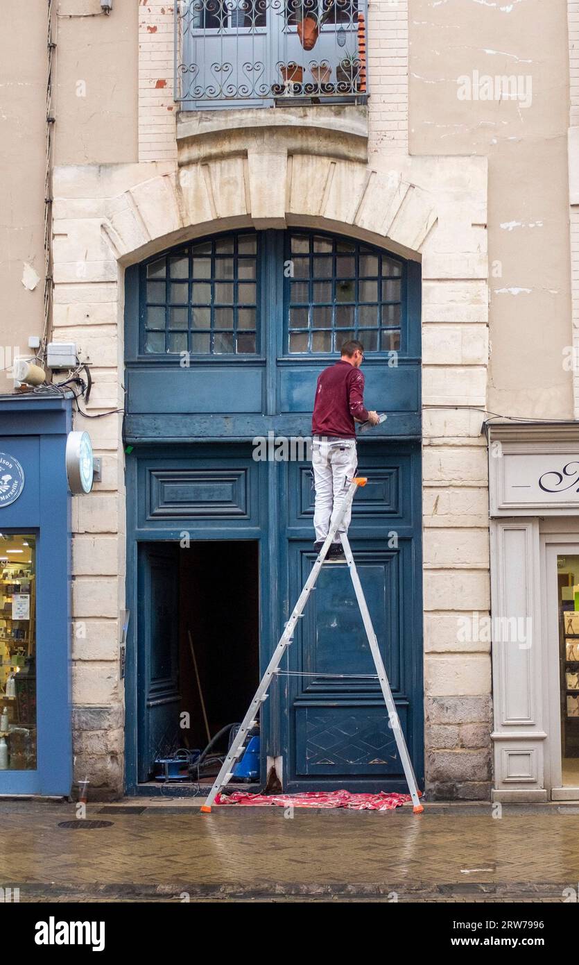 Un uomo che dipinge una porta nella grande Rue a Dieppe , Normandia Dieppe è un porto di pescatori sulla costa normanna della Francia settentrionale Foto Stock