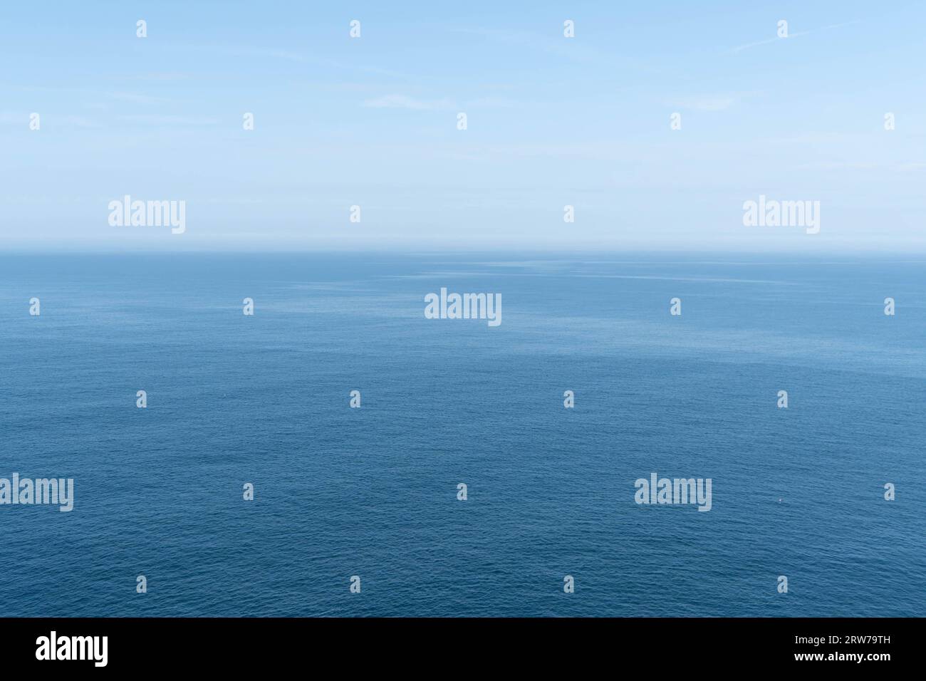 Il tranquillo orizzonte blu dell'oceano incontra il cielo nuvoloso in una giornata tranquilla Foto Stock