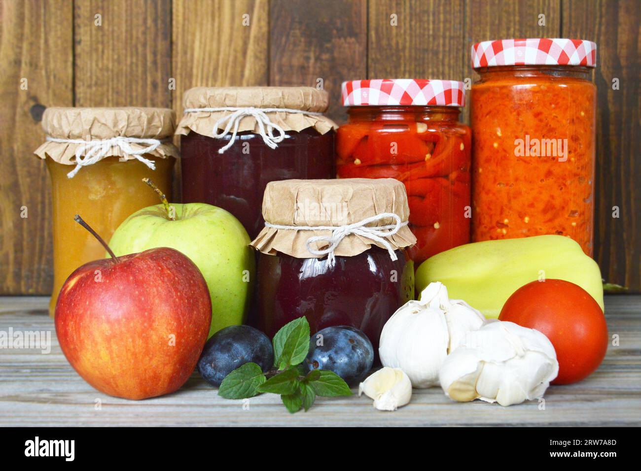 Frutta e verdura conservate e fresche su fondo di legno. Conservare i cibi casalinghi. Foto Stock