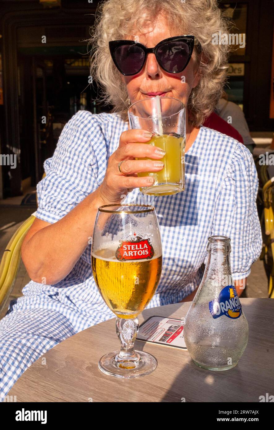 Donna seduta in un bar a Dieppe , Normandia, Dieppe è un porto di pescatori sulla costa normanna della Francia settentrionale Foto Stock