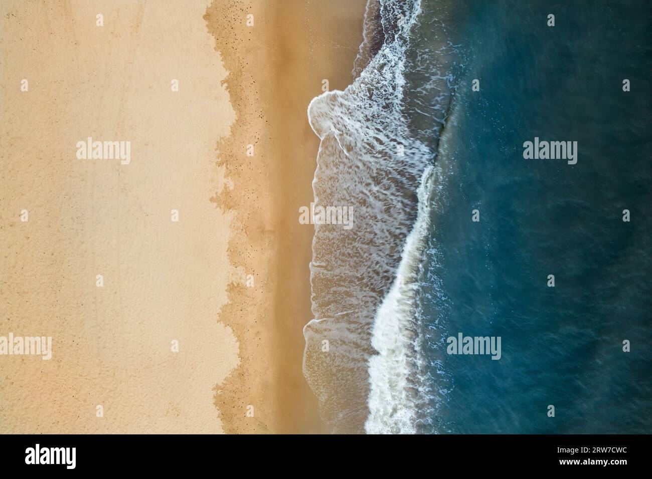 Vista aerea della costa del Mar Baltico con le onde che si infrangono sulla spiaggia di sabbia durante l'alba al mattino, vista degli uccelli, vista dall'alto verso il basso, fotografia con droni Foto Stock