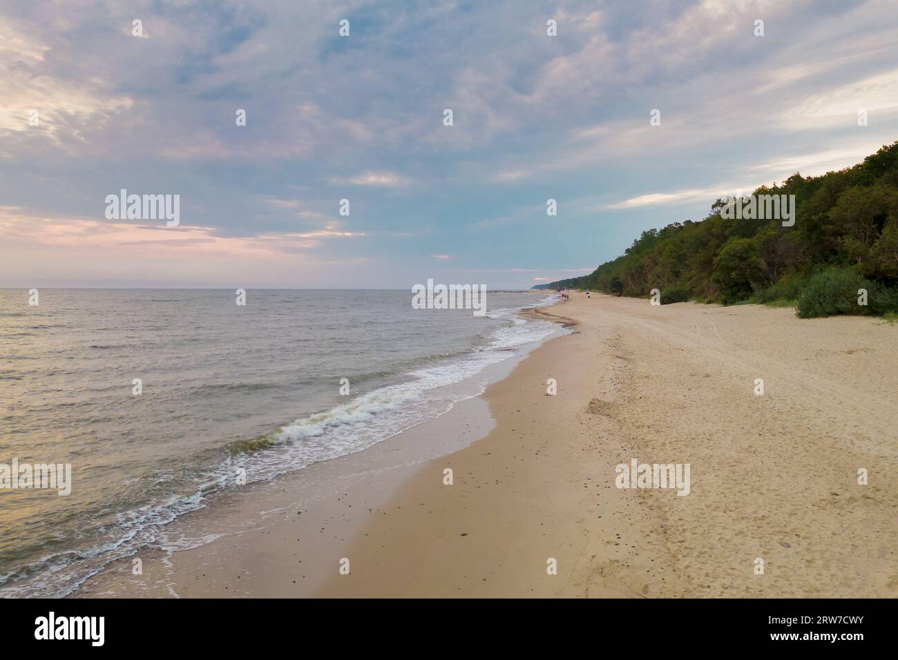 Vista aerea della costa del Mar Baltico con le onde che si infrangono sulla spiaggia di sabbia durante l'alba al mattino, prospettiva dell'uccello, fotografia con droni Foto Stock