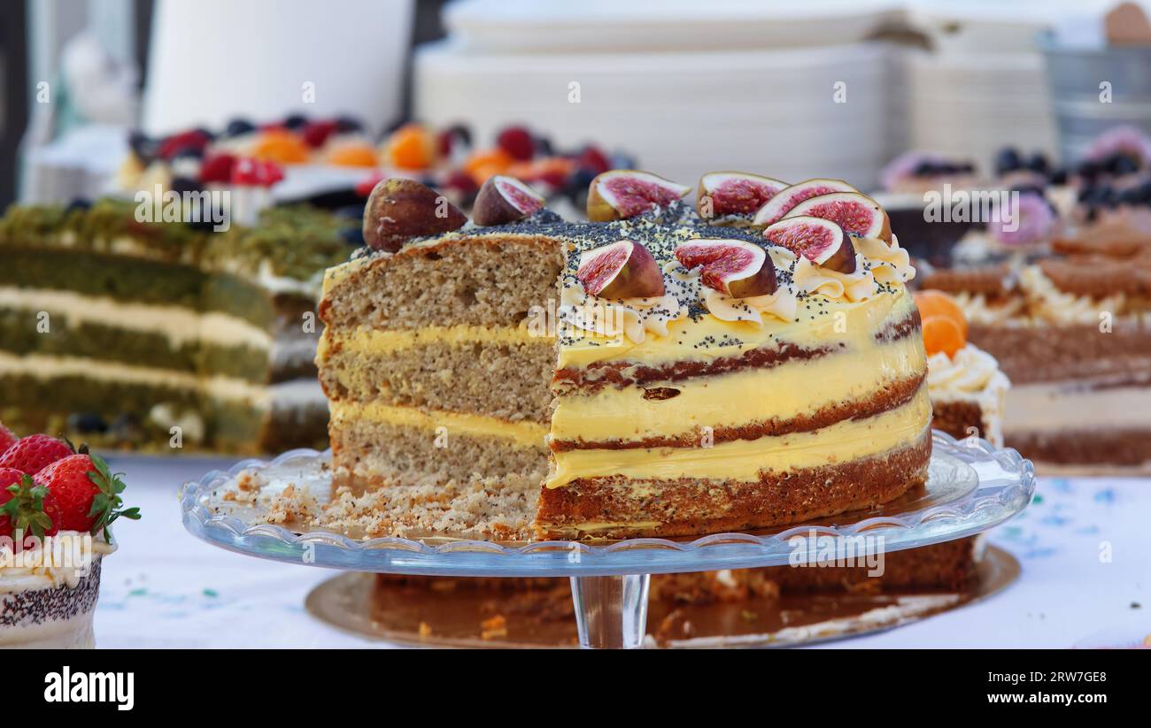 Torta vegana con panna impreziosita da fichi freschi e semi di papavero presso il mercato. Primo piano senza nessuno. Foto Stock