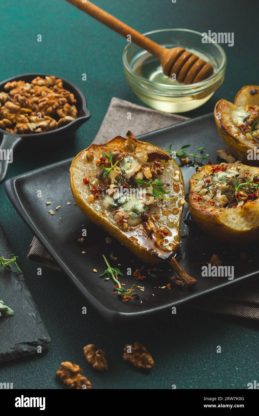 Pere al forno con formaggio blu, noci, miele e timo. Sana cucina francese Appetiser Foto Stock
