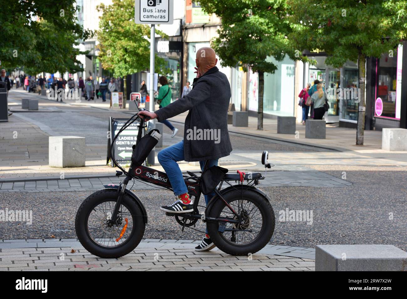 uomo in bicicletta elettrica nel centro di preston Foto Stock