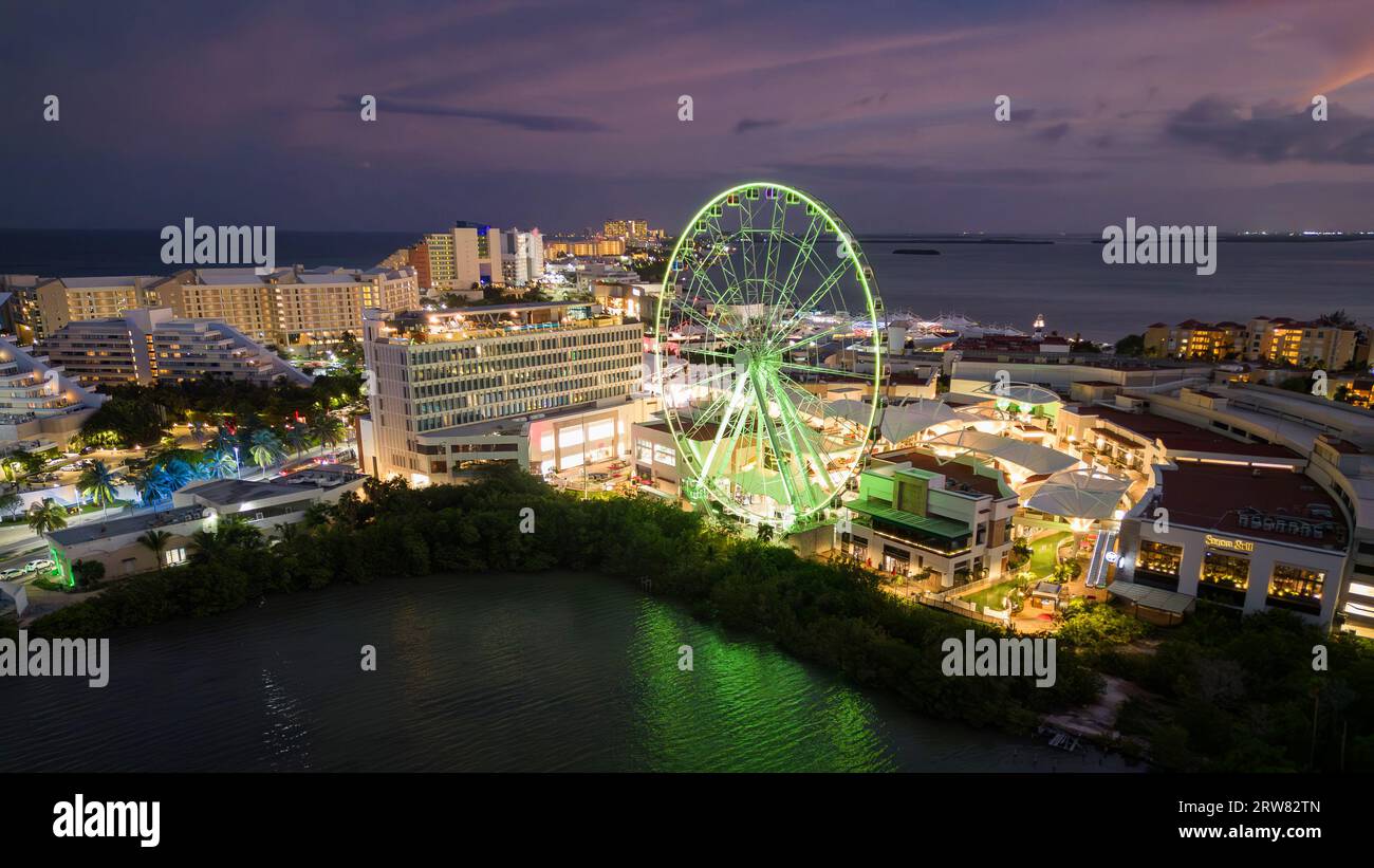 Godetevi l'affascinante vista notturna della zona degli hotel di Cancún. Le vivaci luci dei negozi turistici e dei ristoranti illuminano perfettamente la scena Foto Stock