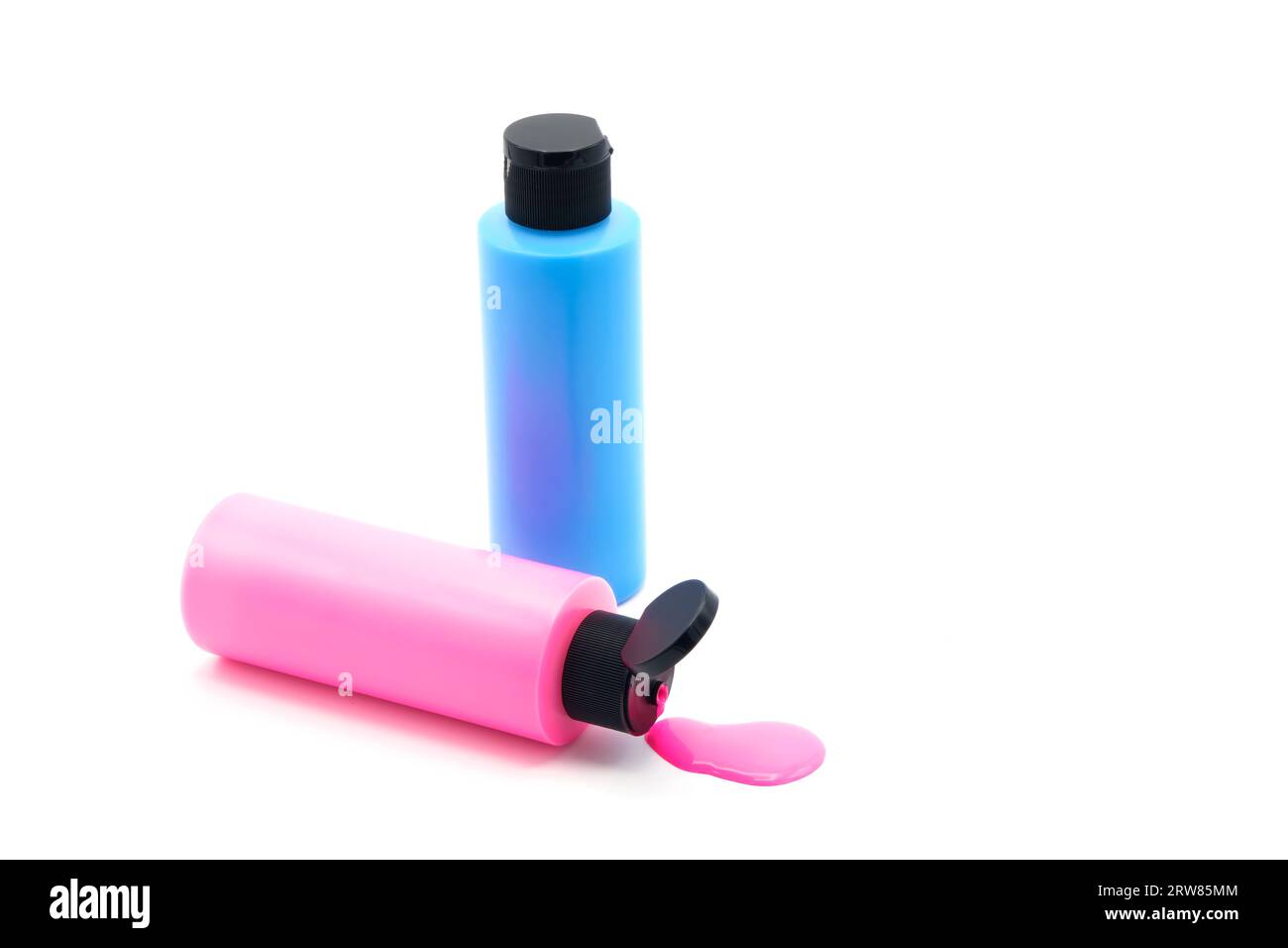 Due contenitori di vernice acrilica, uno rosa e uno blu, fotografati su sfondo bianco. Foto Stock