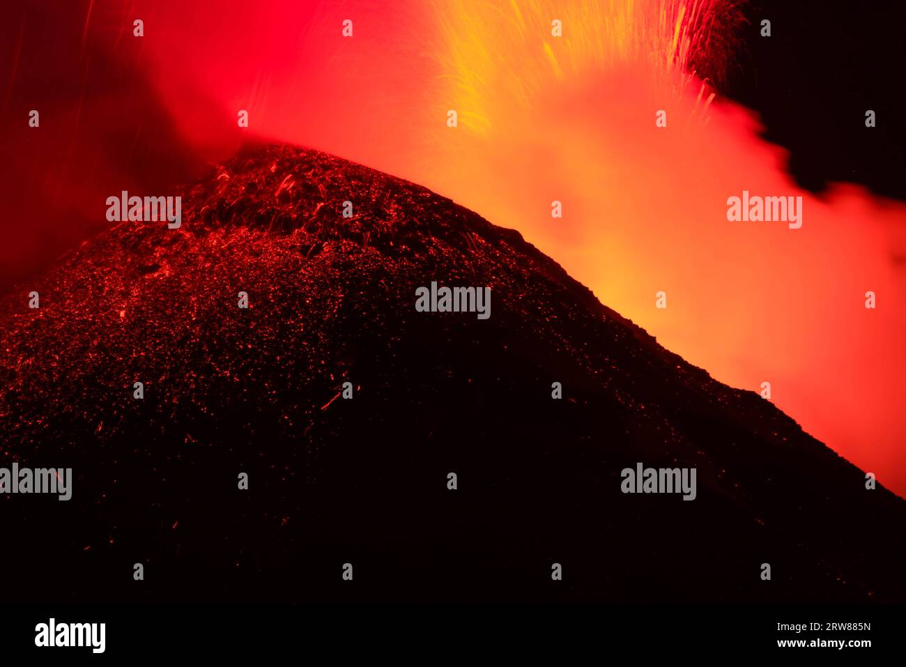 Vista ravvicinata del vulcano Etna sulla grande eruzione di lava di nocturne alla vista retroilluminata della silhouette del cratere superiore Foto Stock