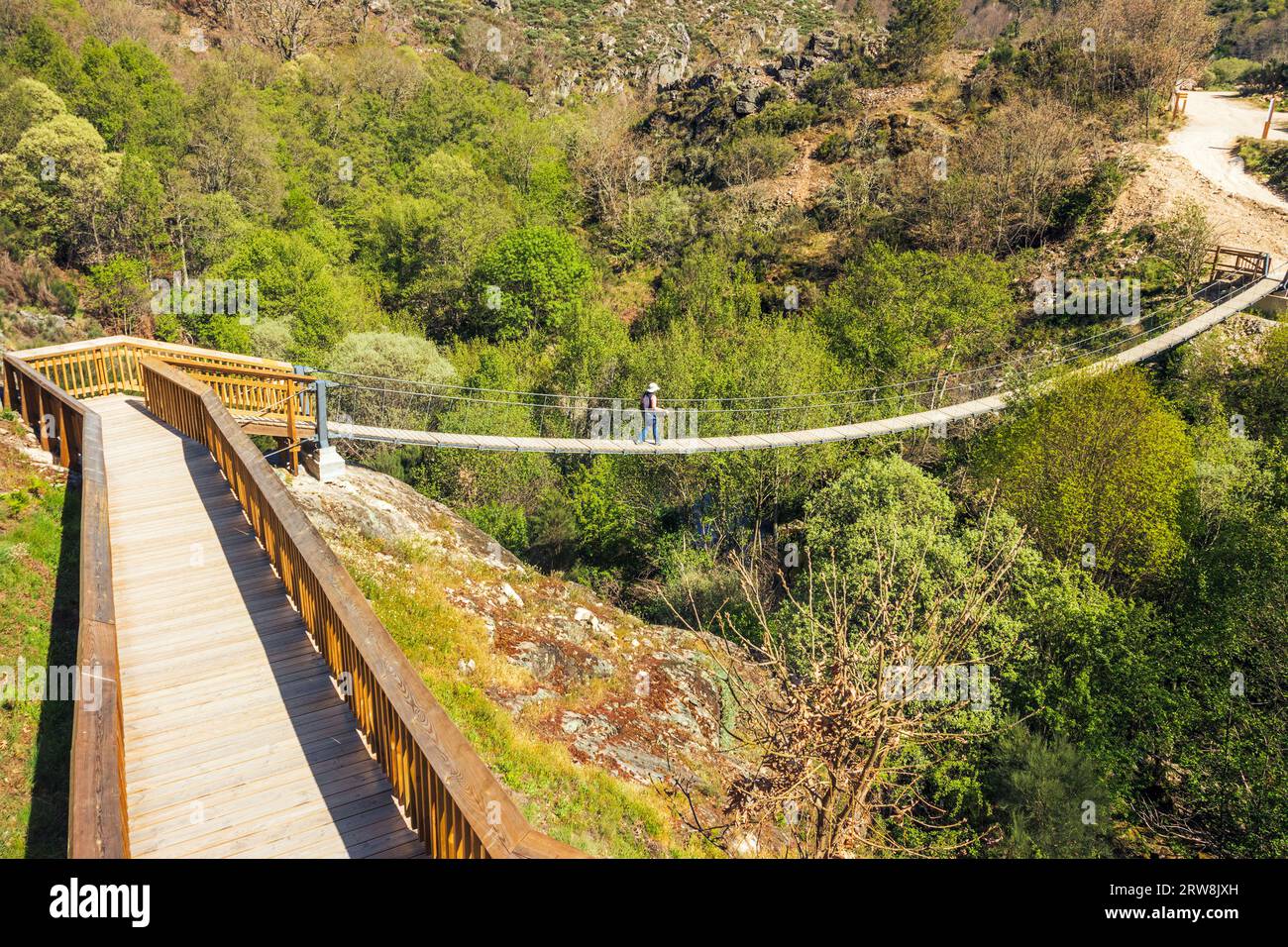 Guarda, Portogallo - 10 aprile 2023: Veduta delle passerelle Mondego con una donna che attraversa un ponte sospeso sul fiume Mondego. Foto Stock