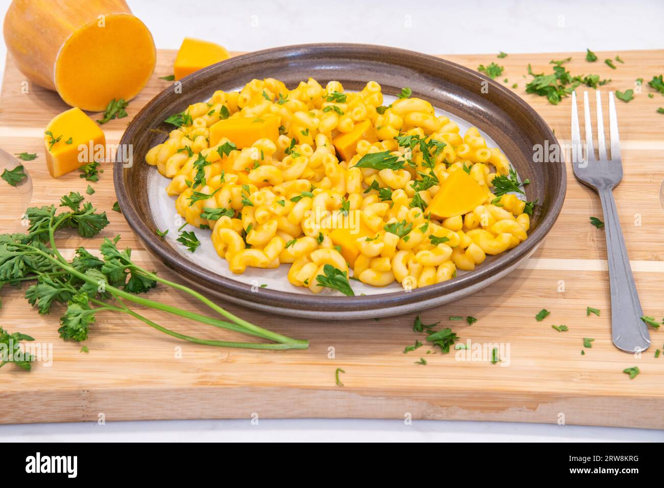 Piatto autunnale di zucca, macaroni e formaggio, placcato su tagliere Foto Stock