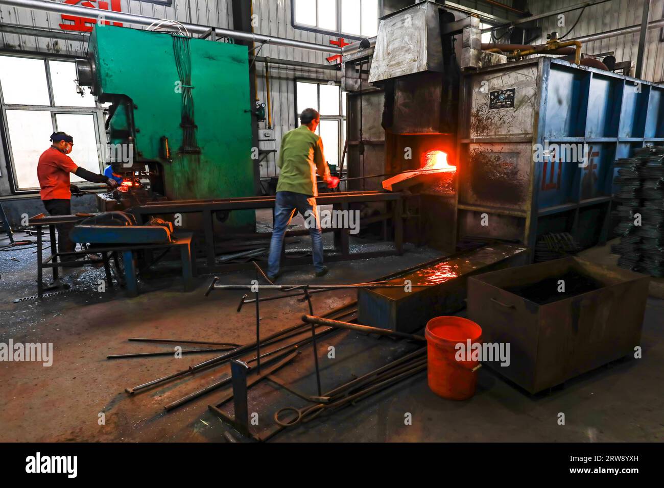 CONTEA DI LUANNAN, Cina - 24 settembre 2021: I lavoratori lavorano intensamente su una linea di produzione di forgiatura in uno stabilimento di produzione di utensili hardware nel nord della Cina Foto Stock