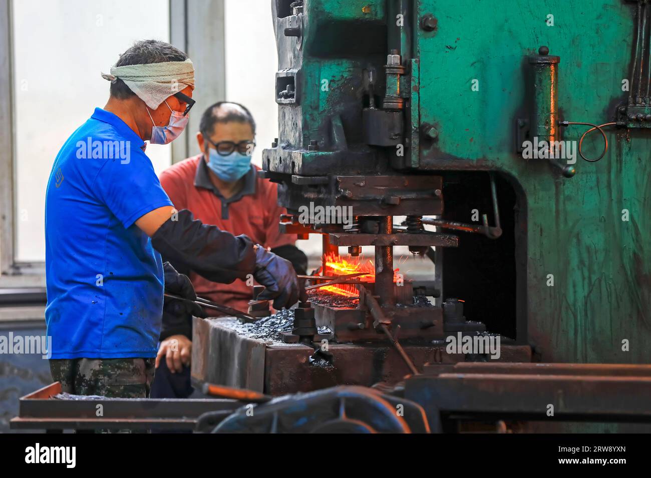 CONTEA DI LUANNAN, Cina - 24 settembre 2021: I lavoratori lavorano intensamente su una linea di produzione di forgiatura in uno stabilimento di produzione di utensili hardware nel nord della Cina Foto Stock