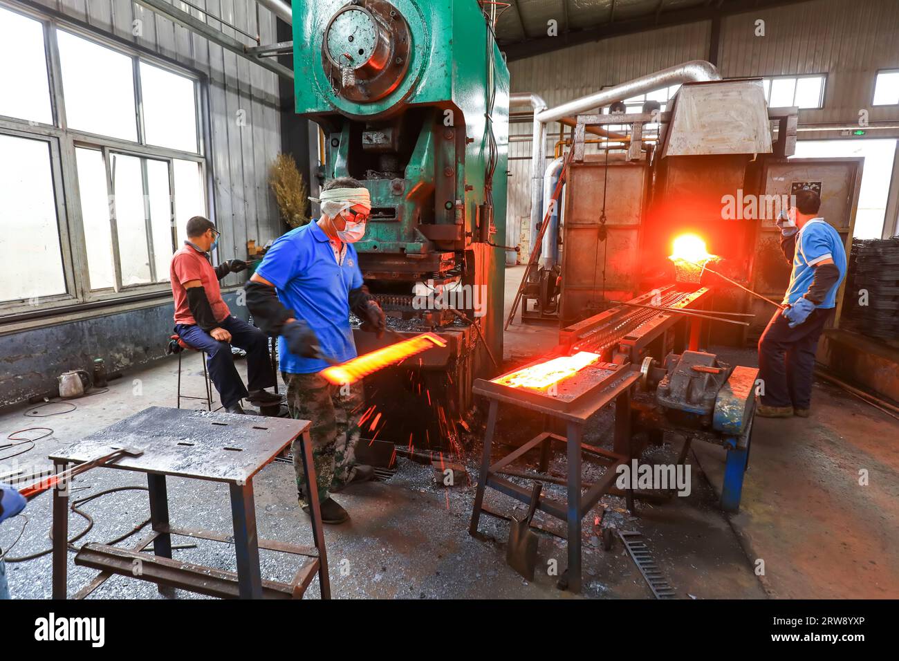 CONTEA DI LUANNAN, Cina - 24 settembre 2021: I lavoratori lavorano intensamente su una linea di produzione di forgiatura in uno stabilimento di produzione di utensili hardware nel nord della Cina Foto Stock